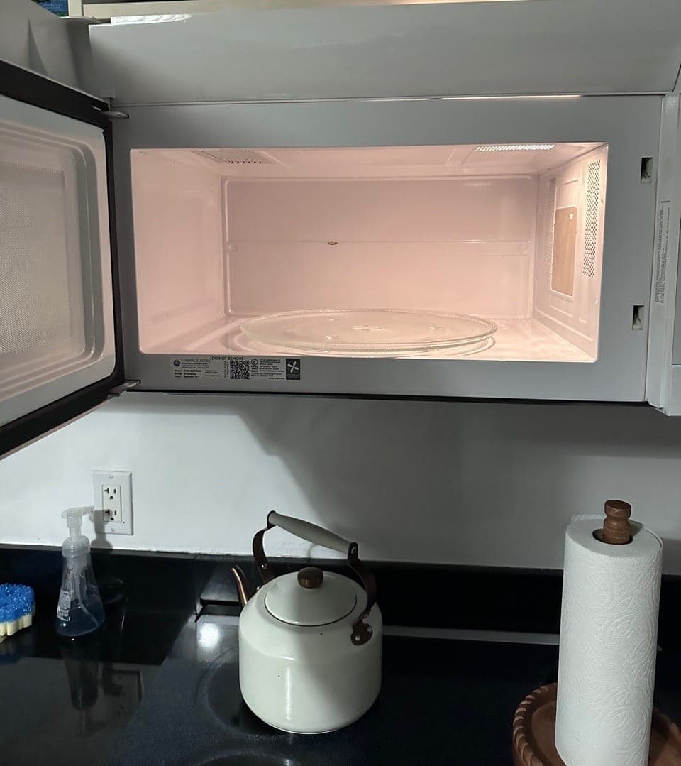 The inside of a microwave, wiped clean, with the door open
