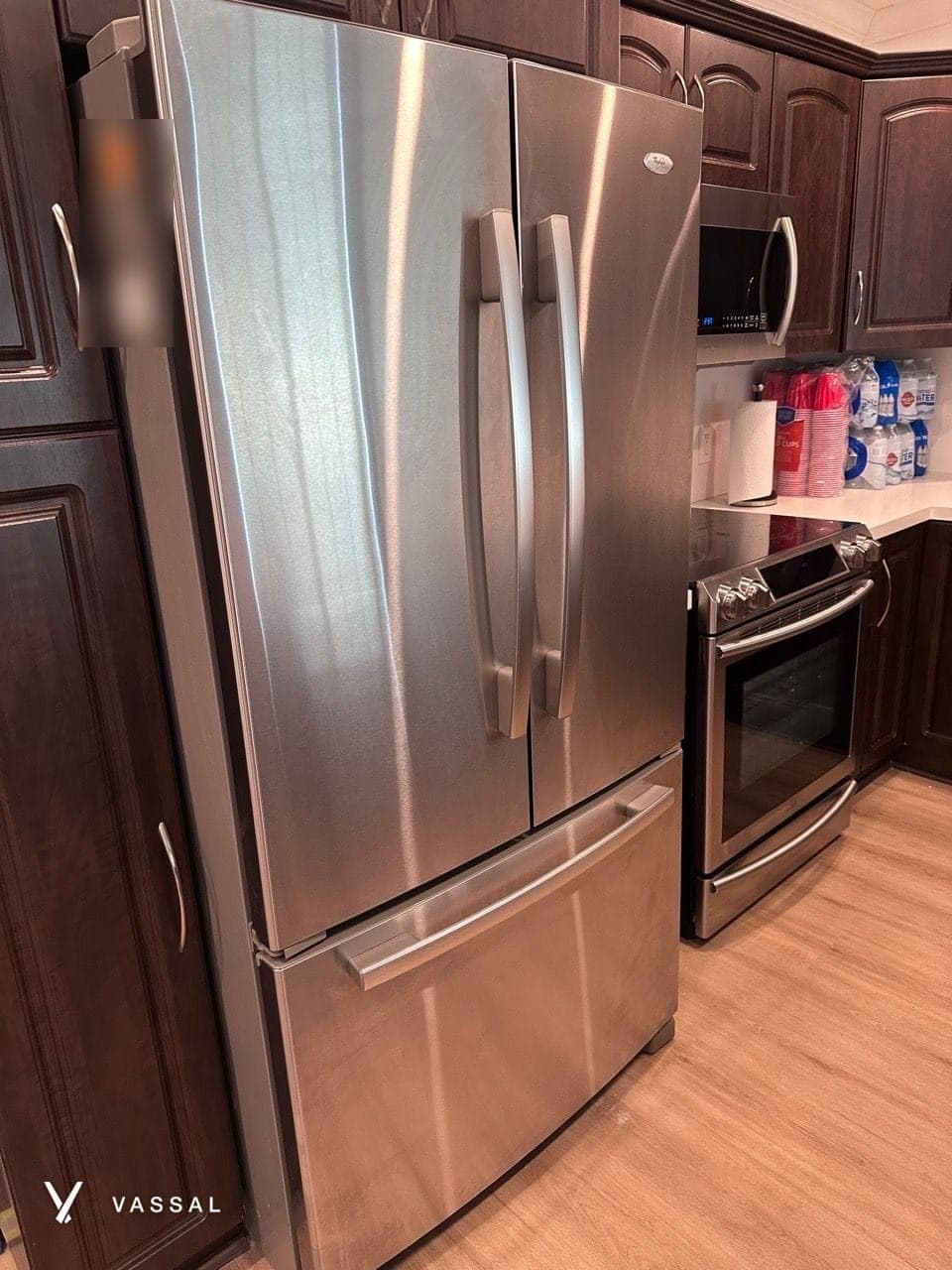 A polished stainless steel fridge and range in a clean kitchen